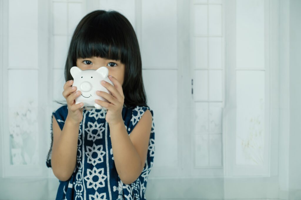 white piggy bank in asian little girl hand learn 2022 11 09 10 09 12 utc
